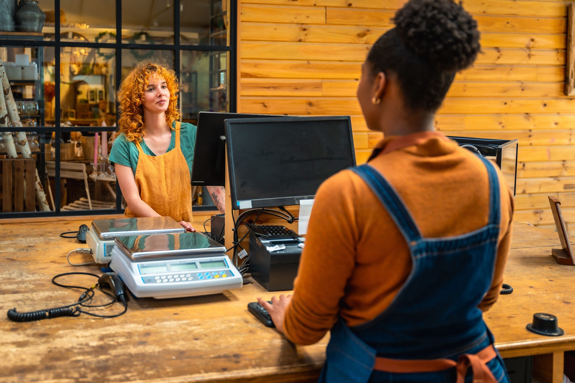 Florist serving customer at checkout counter in flower shop