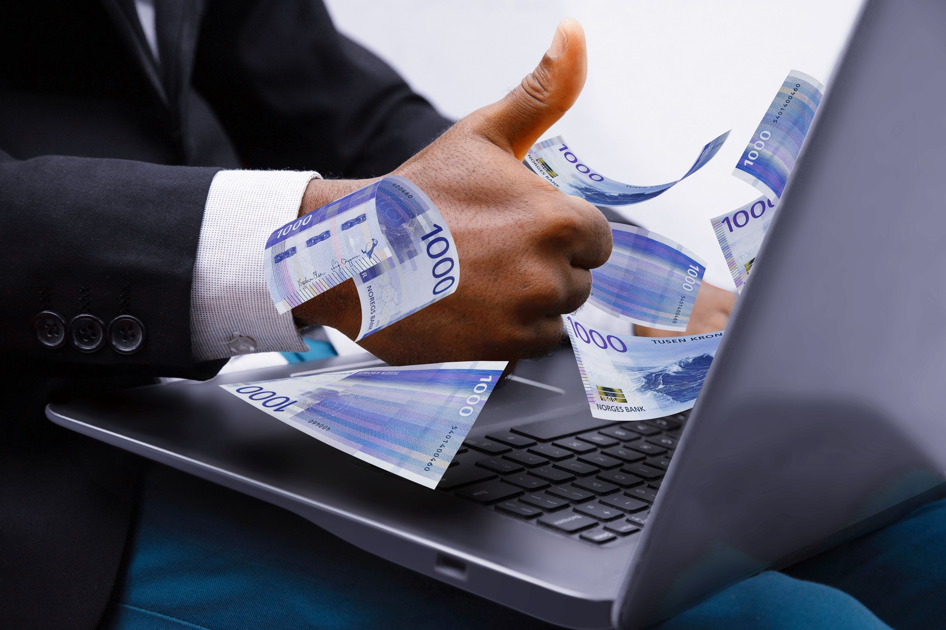 1000 Norwegian krone notes coming out of laptop with Business man giving thumbs up, Financial concept. Make money on the Internet, working with a laptop